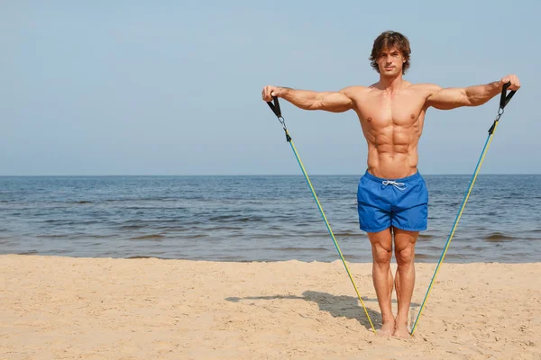 Guy working out with expander — Stock Photo, Image