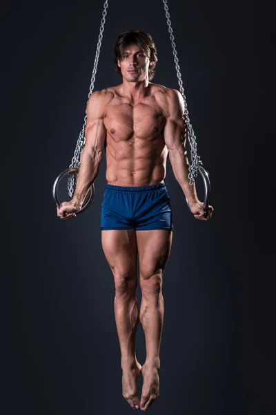 Ginasta masculino muscular em anéis — Fotografia de Stock