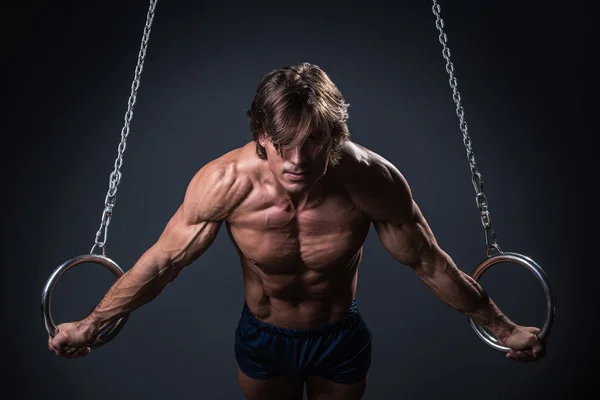 Ginasta masculino muscular em anéis — Fotografia de Stock