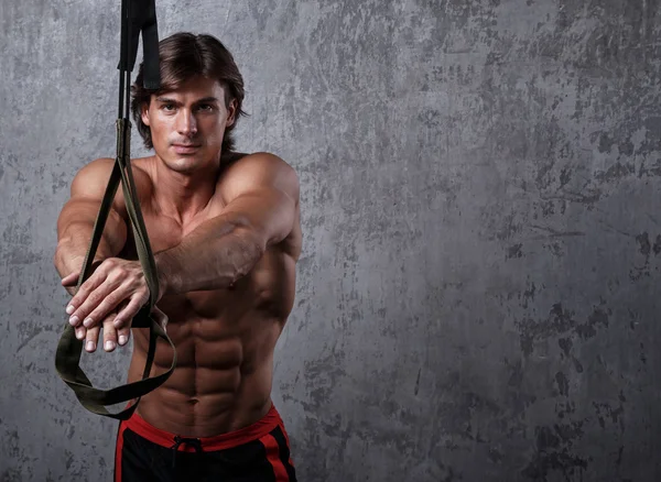 Hombre muscular con correas de suspensión —  Fotos de Stock