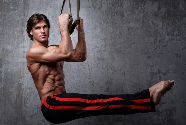 Muscular man with  suspension straps — Stock Photo, Image