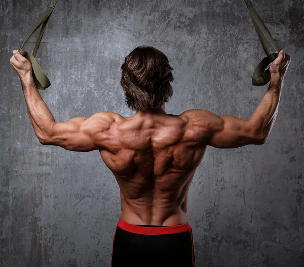 Muscular man with  suspension straps — Stock Photo, Image