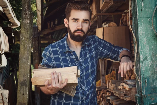 Skäggig man med firewoods — Stockfoto