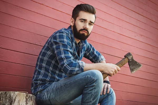 Güdük üzerinde oturan yakışıklı sakallı adam — Stok fotoğraf
