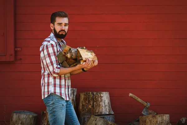 L'homme barbu tient des bois de chauffage — Photo