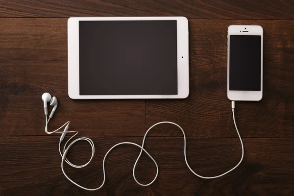 Smartphone and tablet with earphones — Stock Photo, Image