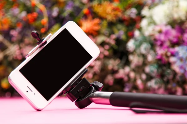 Selfie stick on background with flowers — Stock Photo, Image