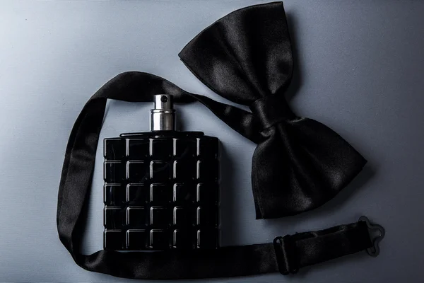 Bottle of male perfume and bow tie — Stock Photo, Image