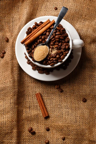 Kopp fylld med kaffebönor och sked — Stockfoto