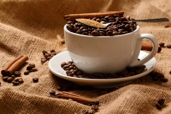 Taza llena de granos de café y cuchara — Foto de Stock