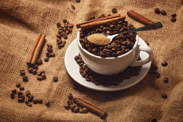 Taza llena de granos de café y cuchara — Foto de Stock