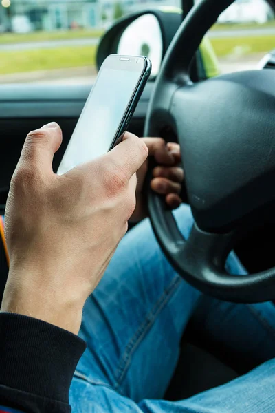 Male hand with smartphone in the car — Stock Photo, Image