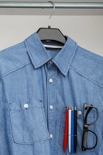 Рубашка с разноцветными ручками и очками в кармане — стоковое фото