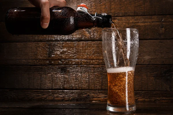 Cerveja está derramando em um copo — Fotografia de Stock