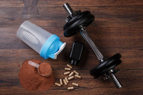 Dumbell and food supplements — Stock Photo, Image