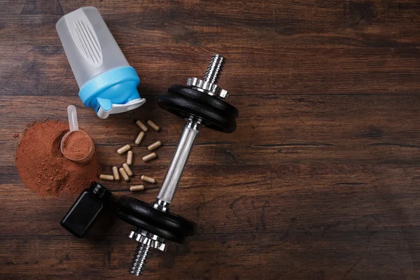 Dumbell and food supplements — Stock Photo, Image