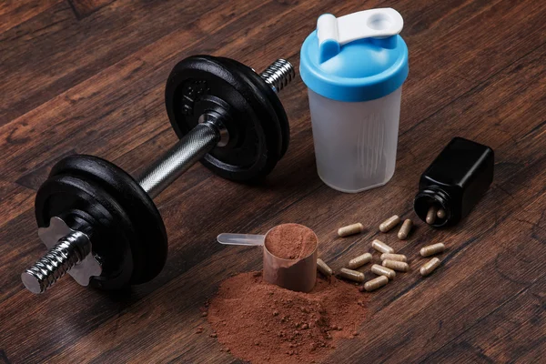 Dumbell and food supplements — Stock Photo, Image