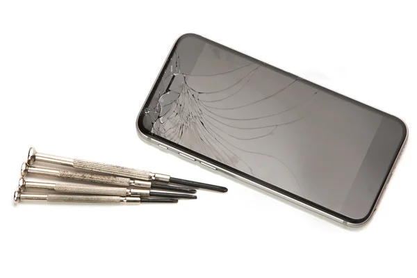 Gebroken smartphone en kleine schroevendraaiers — Stockfoto