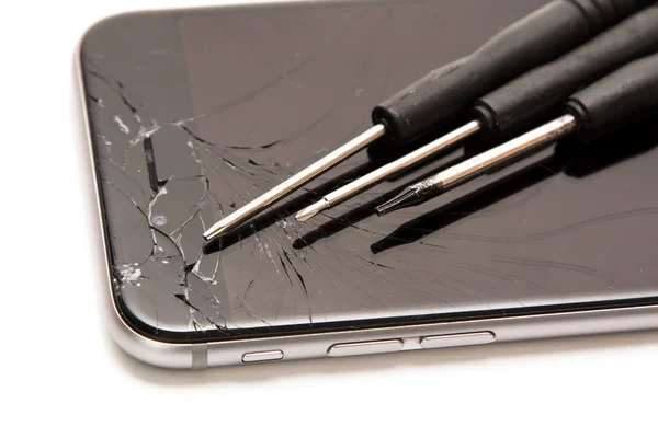 Сломанный смартфон и маленькие отвертки — стоковое фото