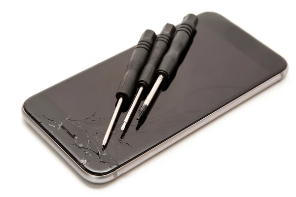 Smartphone quebrado e chaves de fenda pequenas — Fotografia de Stock