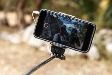 Selfie çubuğundaki akıllı telefon.