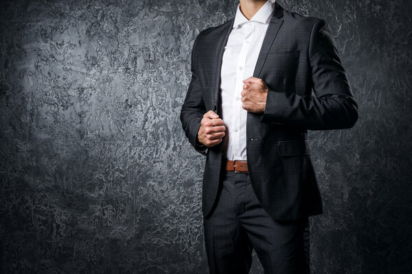 Man in suit against concrete wall