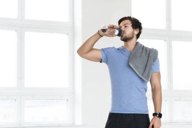 Spor salonunda spor yaptıktan sonra genç ve yakışıklı bir adam.