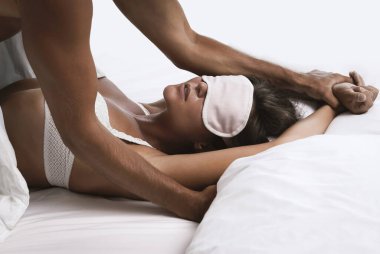 Genç ve güzel bir çift yatakta sevişiyor.