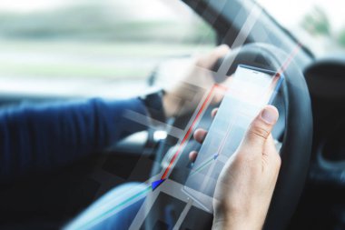 Arabadaki adam GPS navigasyonlu akıllı telefon kullanıyor.