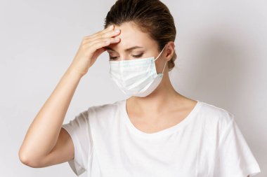 Genç beyaz kadın virüse karşı korunmak için maske takıyor.