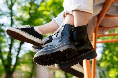 Bir grup genç, şehir parkında maymun parmaklıklarında oturuyor.