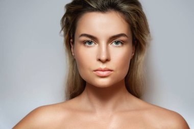 CBD kozmetik konsepti. Gri arka planda esrar yaprağı olan güzel bir kadın.