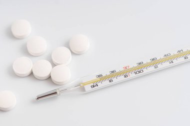 Termometre ve beyaz haplara yakın çekim