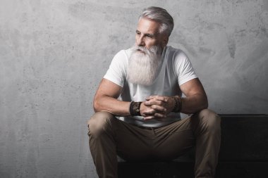 Stüdyoda poz veren şık ve yakışıklı sakallı son sınıf öğrencisi.