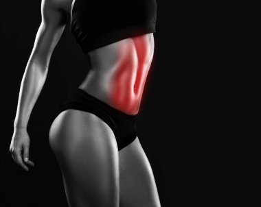 Vücut geliştirmede karın kaslarında uzmanlaşma. Düz göbekli genç fitness kadını.