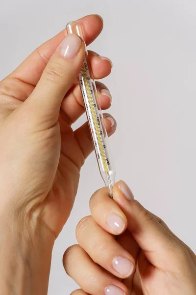 Close Van Vrouwelijke Handen Met Een Thermometer Meting Van Lichaamstemperatuur — Stockfoto