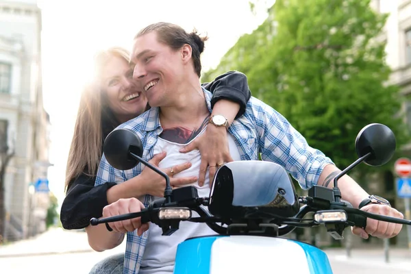 Young stylish couple with a motorcycle on a city street