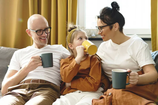 快乐的家庭在舒适的公寓客厅里喝热茶 — 图库照片