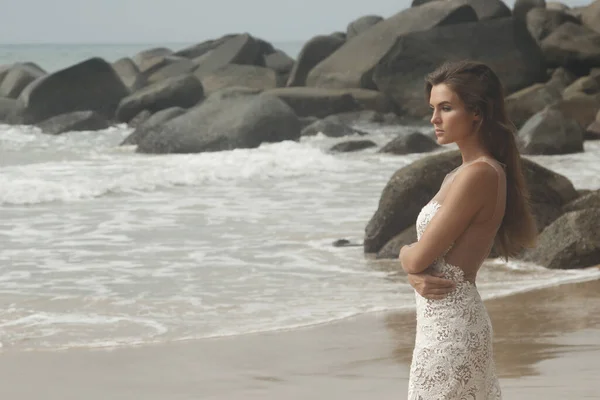 Молодая Женщина Красивом Белом Платье Позирует Скалистом Пляже — стоковое фото