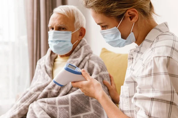 Genç Bir Kadın Evde Soğuk Algınlığıyla Yaşlı Büyükbabasına Bakıyor — Stok fotoğraf