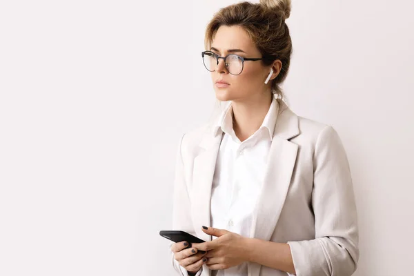 Young Businesswoman Talking Phone Using Wireless Earbuds Gray Background — Stock Photo, Image