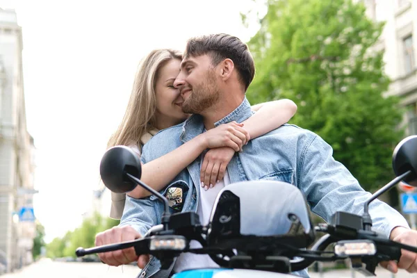 Young stylish couple with a motorcycle on a city street