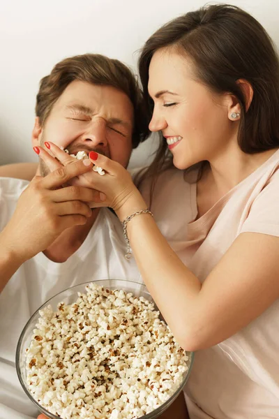 年轻快乐的夫妻在家里吃爆米花和看电影 — 图库照片