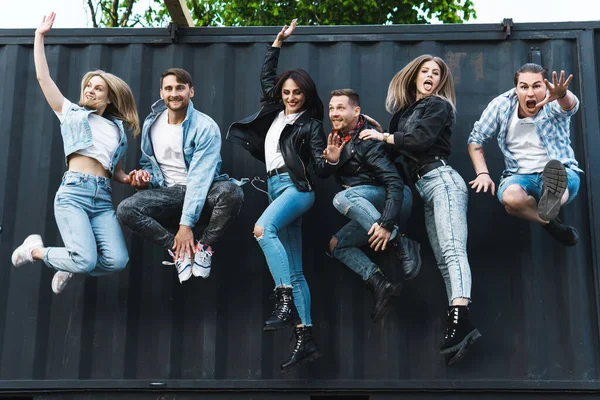 Group of young and stylish people jumping in the air on a city street