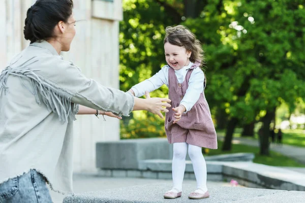 幸せな母親と彼女の可愛いです娘遊びます上の通り — ストック写真