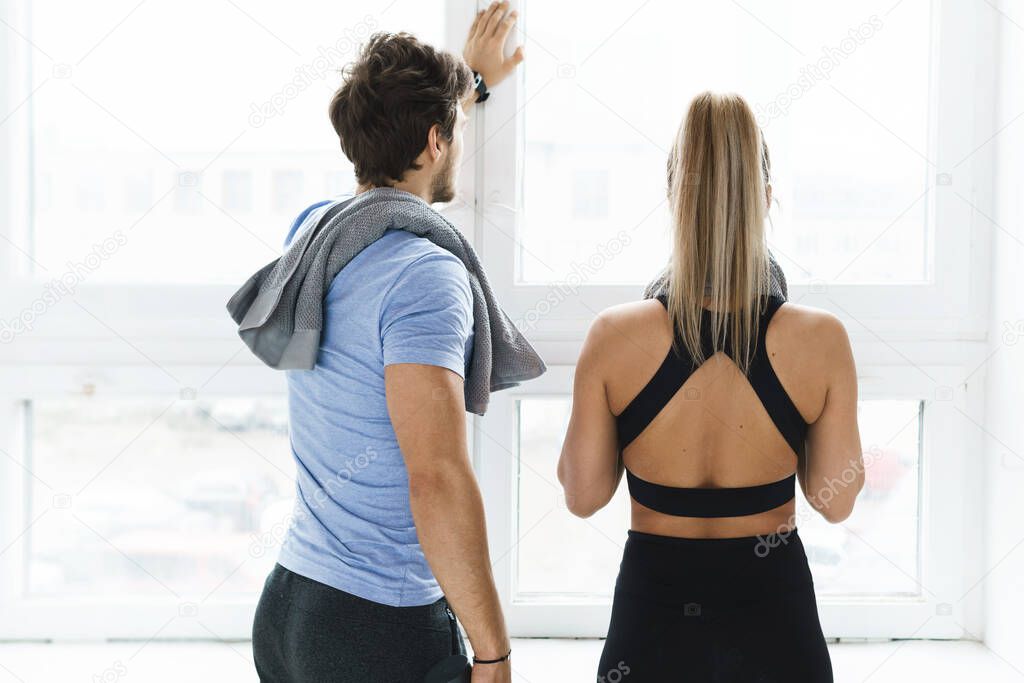 Man and woman resting after fitness workout in the gym
