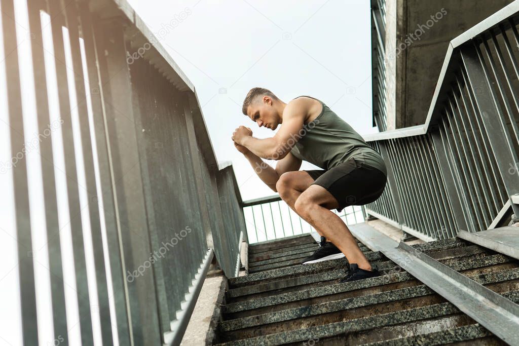 Young and muscular man during workout on a stairscase