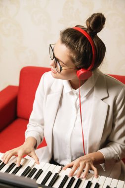 Evde sentezleyici çalan genç ve güzel bir kadın.