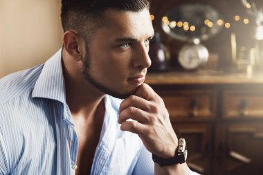 Mavi gömlek giyen yakışıklı genç adamın portresi.