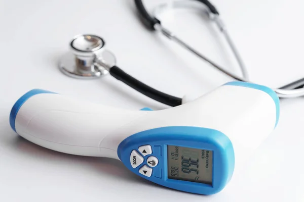 Close-up of digital infrared thermometer and stethoscope